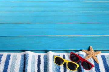 Beach background border striped towel sunglasses and starfish on old weathered blue wood deck decking for summer vacation holiday photo