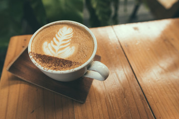 Hot coffee, Capucino coffee on the wooden table in selective focus.