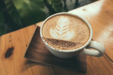 Hot coffee, Capucino coffee on the wooden table in selective focus.