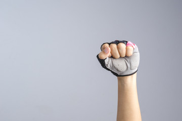 A hand wearing bicycle glove with clenched fist sign