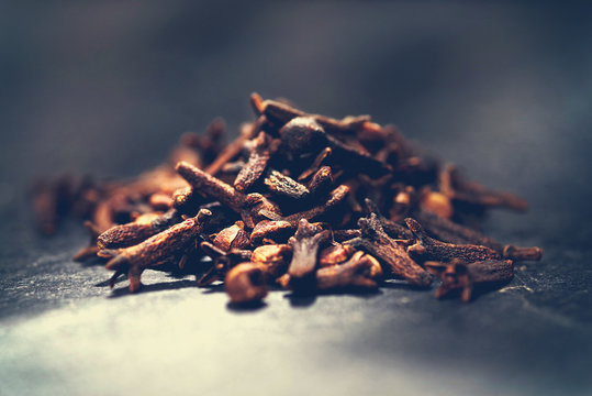Cloves. Spice in spoon on texture background