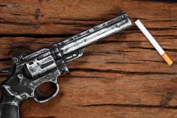 Cigarette and plastic toy gun represent stop smoke cigarette concept idea.