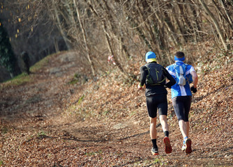 Two runners run along the mountain trail during the racing race