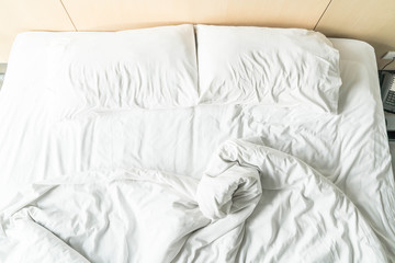 rumpled bed with white messy pillow