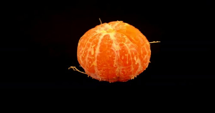 Satsuma peeling off the skin in healthy eating concept revealing fresh juicy orange in the middle