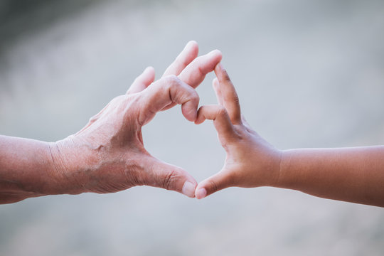 Grandmother and kid little girl making heart shape with hands together with love in vintage color tone