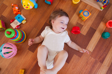 cheerful baby with group of  toys on a floor