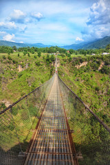 Fototapeta na wymiar Long suspension bridge over a deep gorge