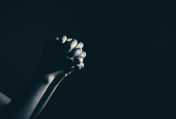 praying woman hand in the dark ( praying in secret room concept )