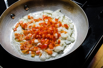 Red peppers and onions sauting in fry pan