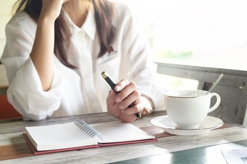 business woman talking on phone while holding pen for make a note on book. this image for business and portrait concept