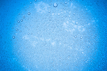 Rain droplets on blue glass background, Water drops on glass.