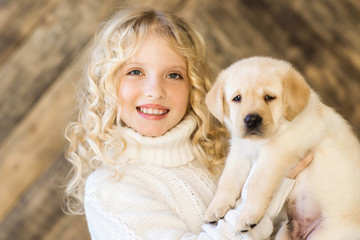 Little girl with a labrador puppy