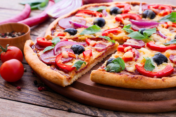 Delicious pizza served on wooden table. Italian pizza close up, top view, horizontal