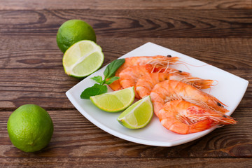 Delicious fresh seafood shrimp with lime on wooden table