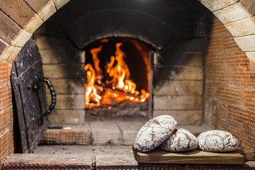 Crispy loaf of bread lying on the edge of the Russian stove on the hearth