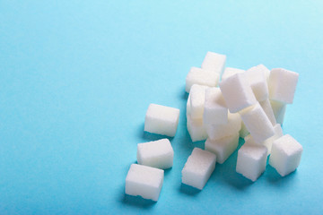 Sugar cubes scattered on a blue background with an empty space for text