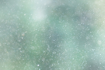 Naklejka na ściany i meble Snowfall texture of snowflakes on blurred background