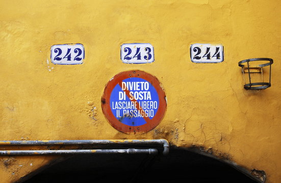 divieto di sosta dipinto su muro giallo in centro storico
