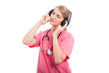 Female nurse wearing scrubs enjoying listening music