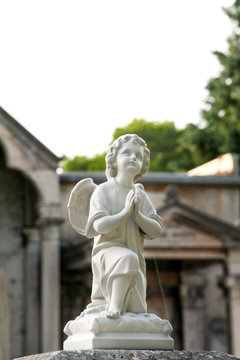 Statues marble of child angel. Tombstones in cemetery. Old cemetery with tombstones. Sculpture Art.