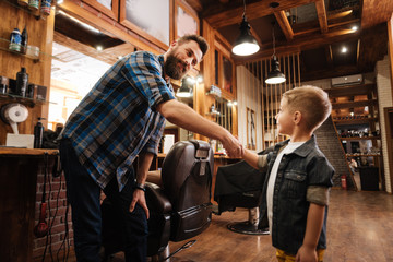 Joyful happy man shaking hands with his client