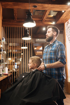 Delighted male barber standing behind his client