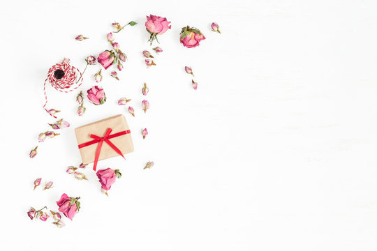 Flowers composition. Gift and dried rose flowers on white background. Flat lay, top view