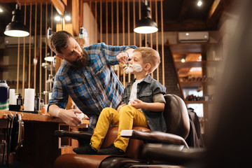 Professional nice barber using a shaving foam