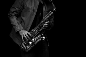 Jazz saxophone musician in the leather jacket, closeup. - obrazy, fototapety, plakaty