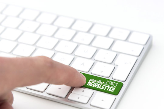 finger pressing a green key labeled subscribe to NEWSLETTER with envelope symbol on a computer keyboard concept