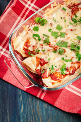 Traditional mexican enchiladas with chicken meat, spicy tomato s