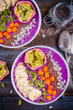Blueberry smoothies bowl with sea-buckthorn, banana, passion fruit, chia seeds, pumpkin seeds, sunflower and flax seeds