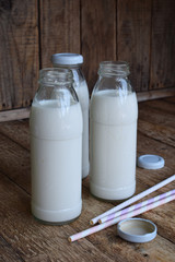 Sour-dairy drink or yoghurt in bottle that come from the kefir grains and milk on wooden background. Photographed with natural light