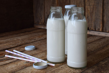 Sour-dairy drink or yoghurt in bottle that come from the kefir grains and milk on wooden background. Photographed with natural light