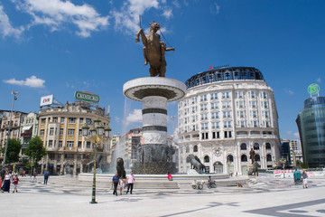 Unidentified people pass the fountain monument to Alexander the Great in Macedonia Square, Skopje,...