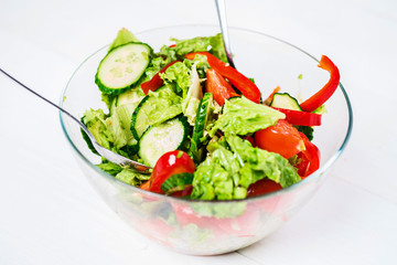 Vegetable salad with olive oil on a white background