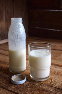 Sour-dairy drink or yoghurt in bottle that come from the kefir grains and milk on wooden background. Photographed with natural light