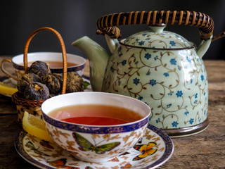 Teapot and glass cups with tea against wooden background