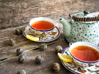 Teapot and glass cups with tea against wooden background