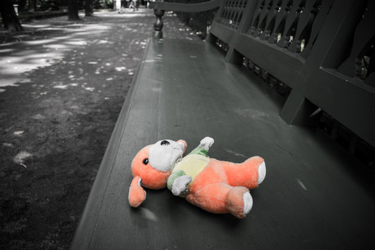Soft children's toy lying on a wooden bench
