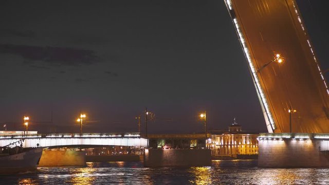 Night. Barge, cargo ship floats through a drawbridge along the Neva River in Saint Petersburg.
