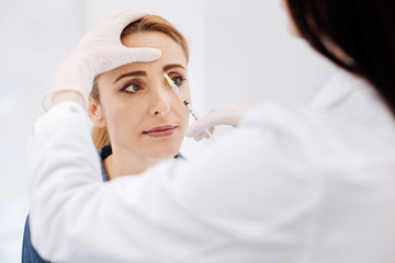 Serious nice woman visiting a cosmetologist