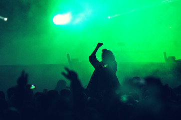 Crowd at a music concert, audience raising hands up