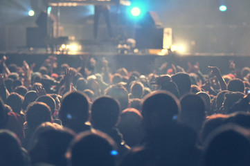 Fototapeta na wymiar Crowd at a music concert, audience raising hands up