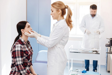 Obraz premium Nice plastic surgeon holding her patients face