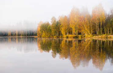 Fototapeta premium Scenic landscape with lake and fall colors at morning light