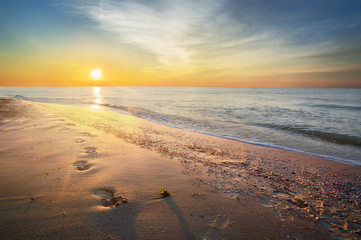 Footprints on the beach, dawn on the sea