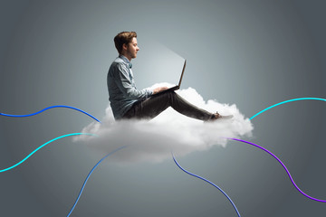Mann arbeitet an seinem Notebook auf einer Wolke