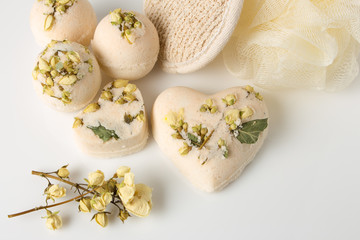 Bath bombs decorated with dried linden flowers on a white